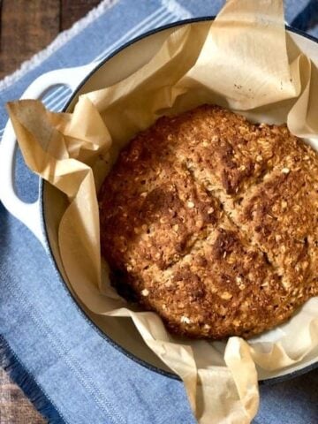 baked Irish soda bread with an x pattern on top in a Dutch oven