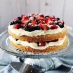 Italian berry cake on a cake stand on a blue table