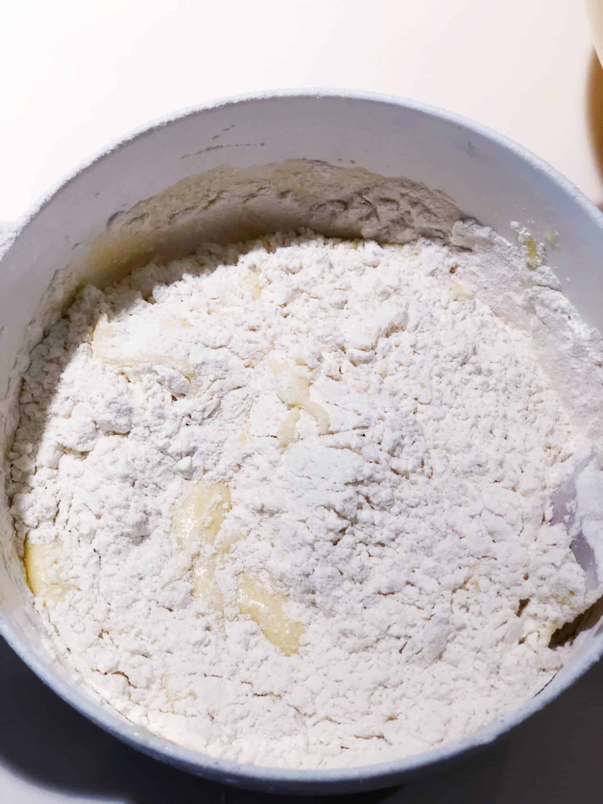 adding flour to egg mixture for apple cake batter