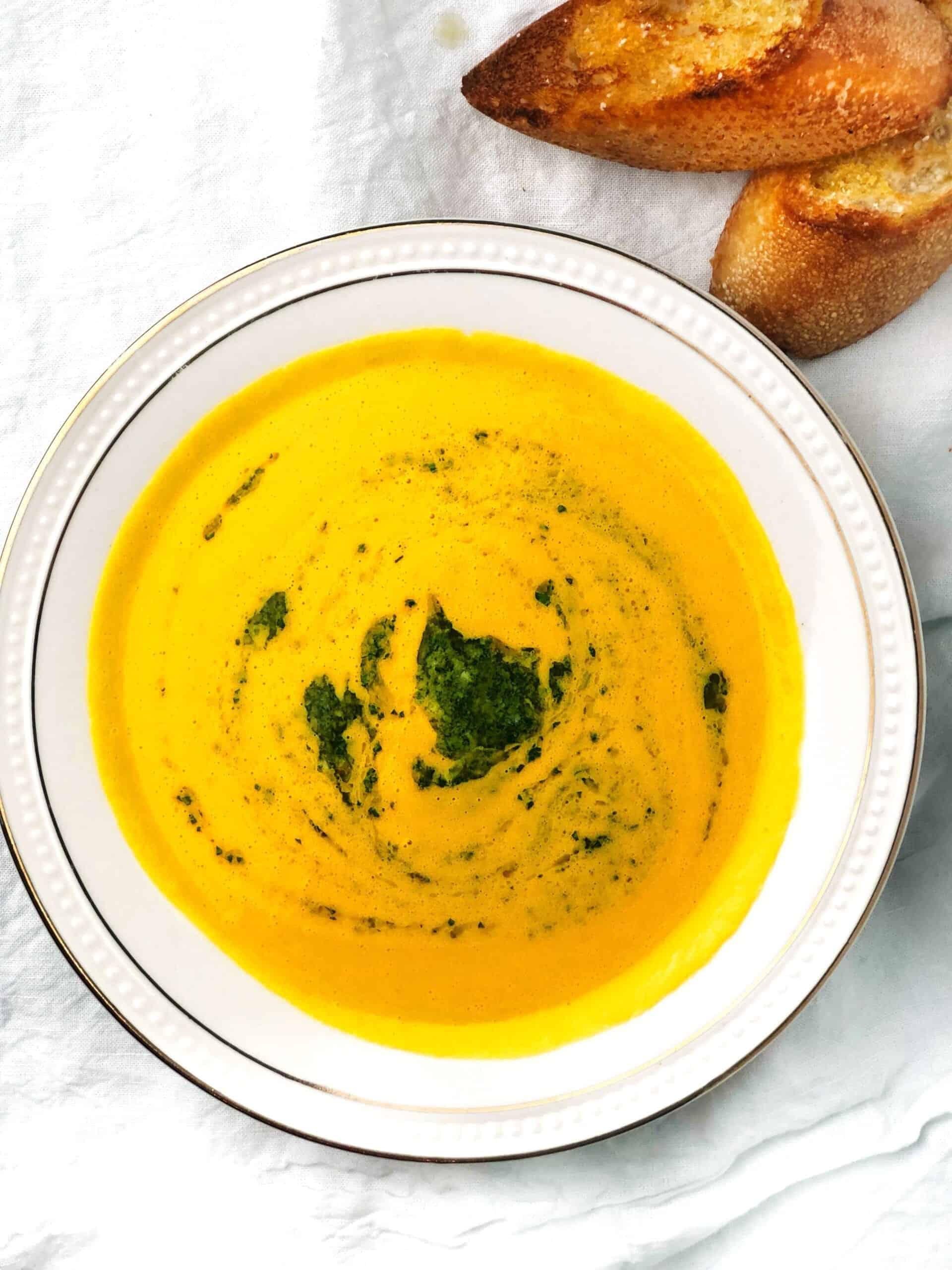roasted acorn squash soup in white bowl.