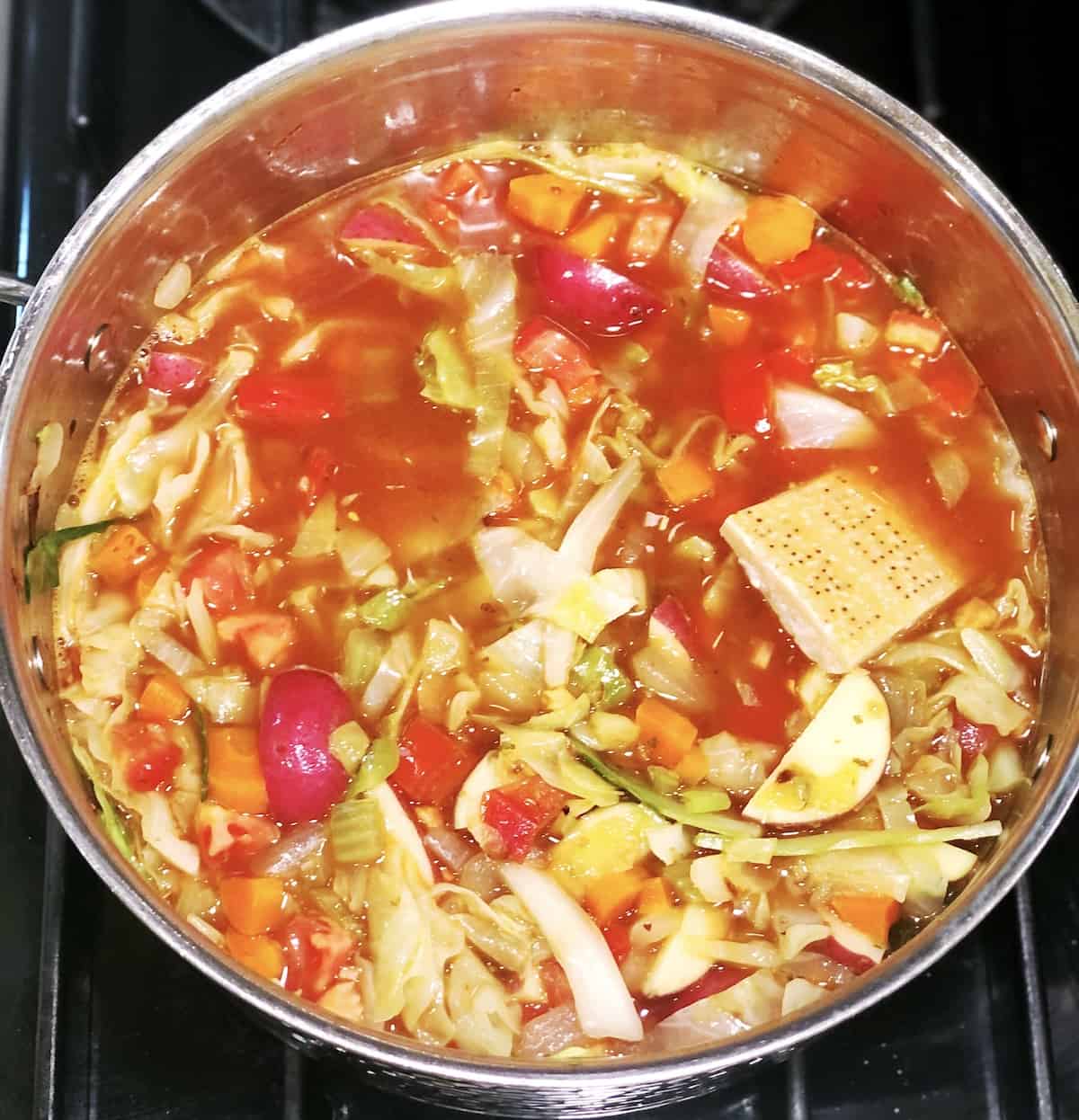 assembling vegetable soup with cabbage