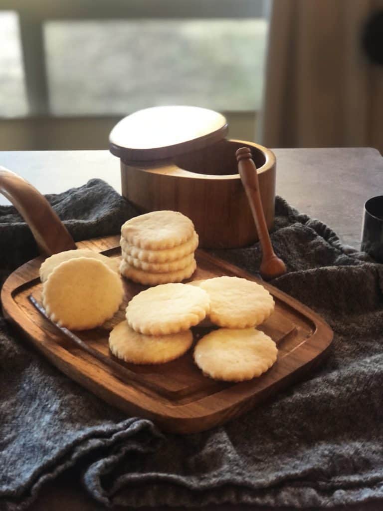 A wooden cutting board with salted shortbread cookies and a wooden spoon.