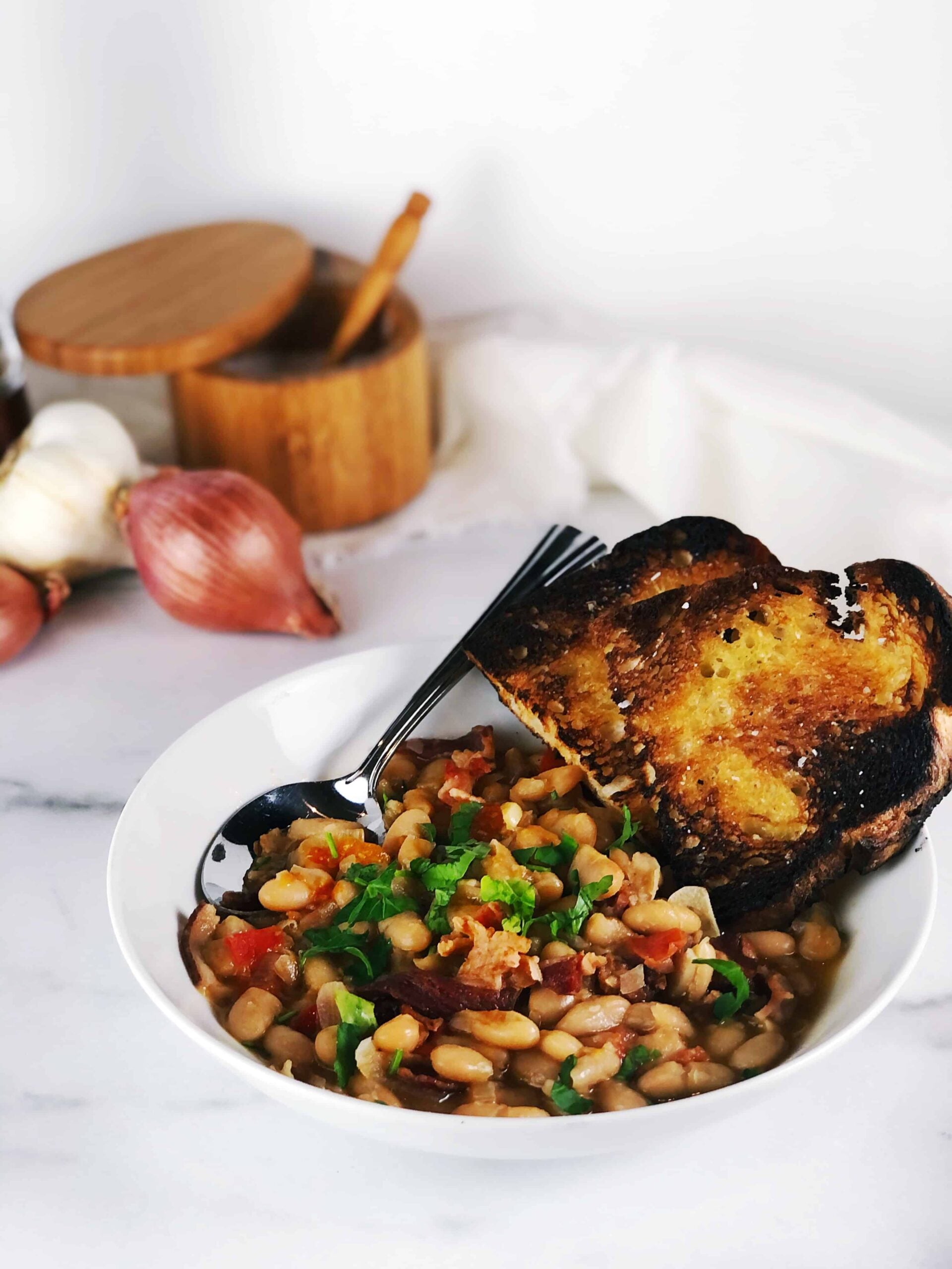 white bean ragout in bowl with crostini