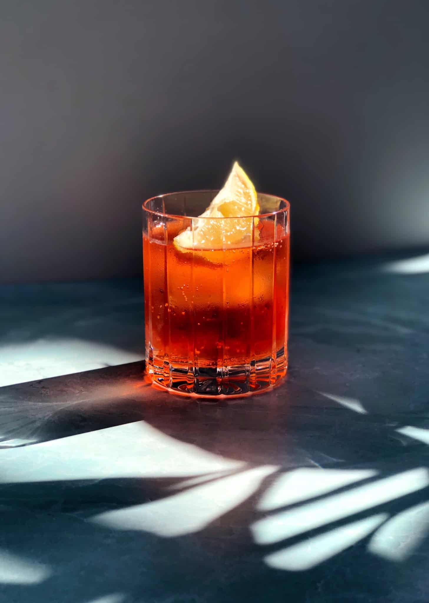 Aperol and soda in glass with lemon wedge