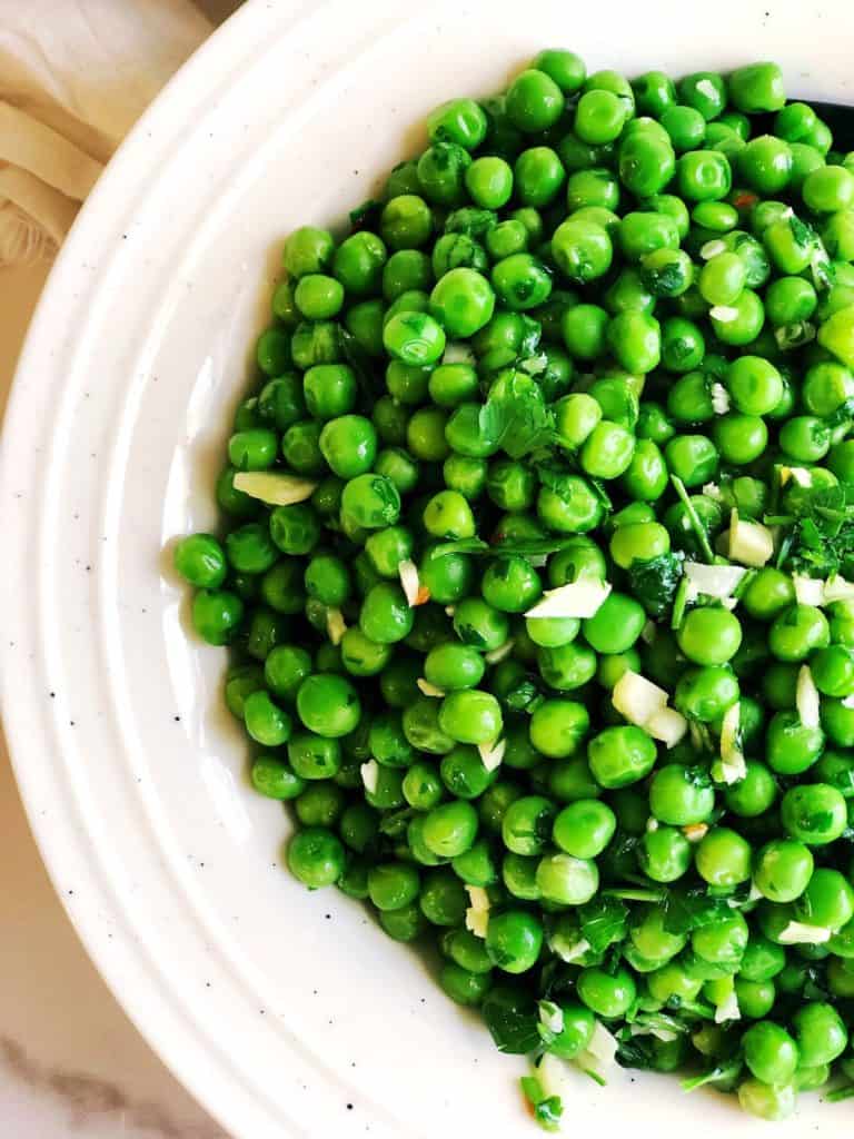 Closeup of Italian peas with garlic and parsley in a bowl