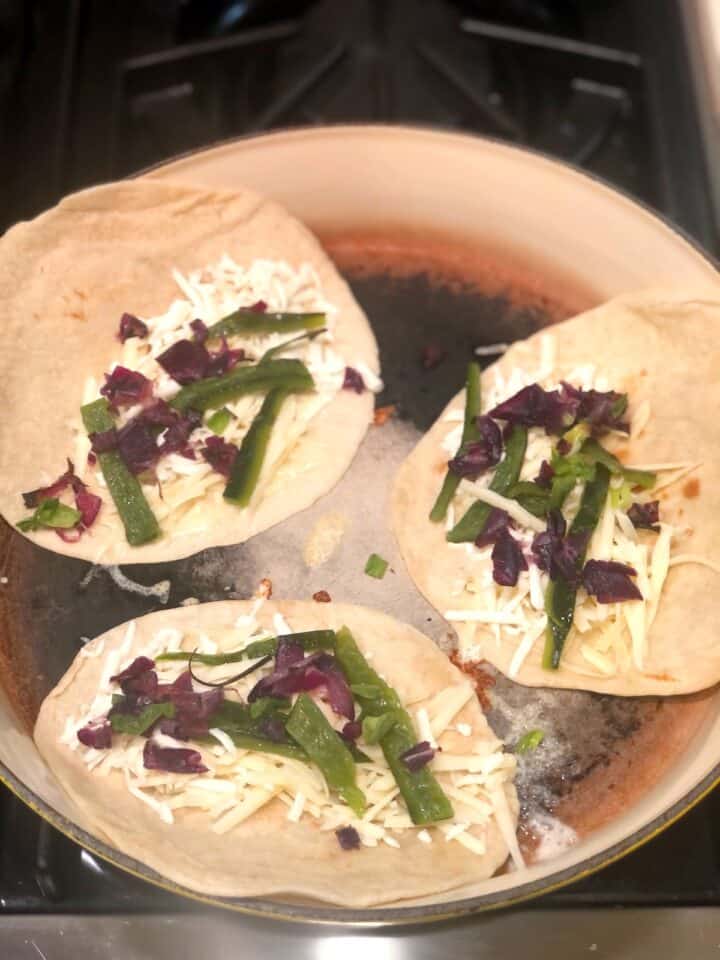 adding the ingredients to quesadilla
