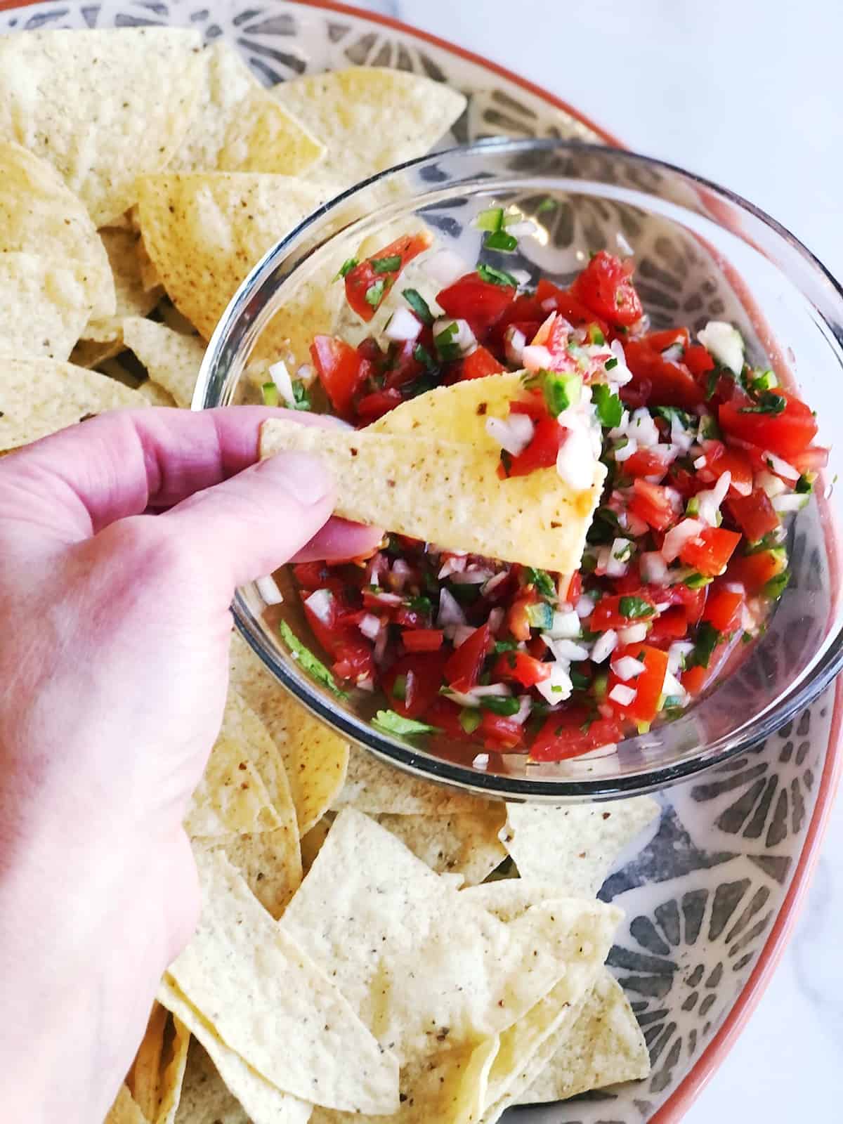 scooping up homemade pico de gallo
