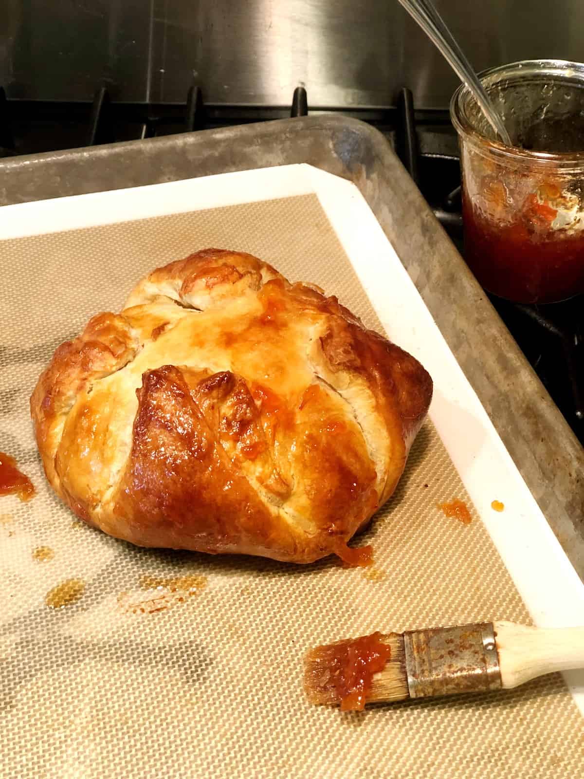 adding jam to baked brie