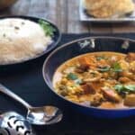 Indian vegetable curry with coconut milk in bowls on table