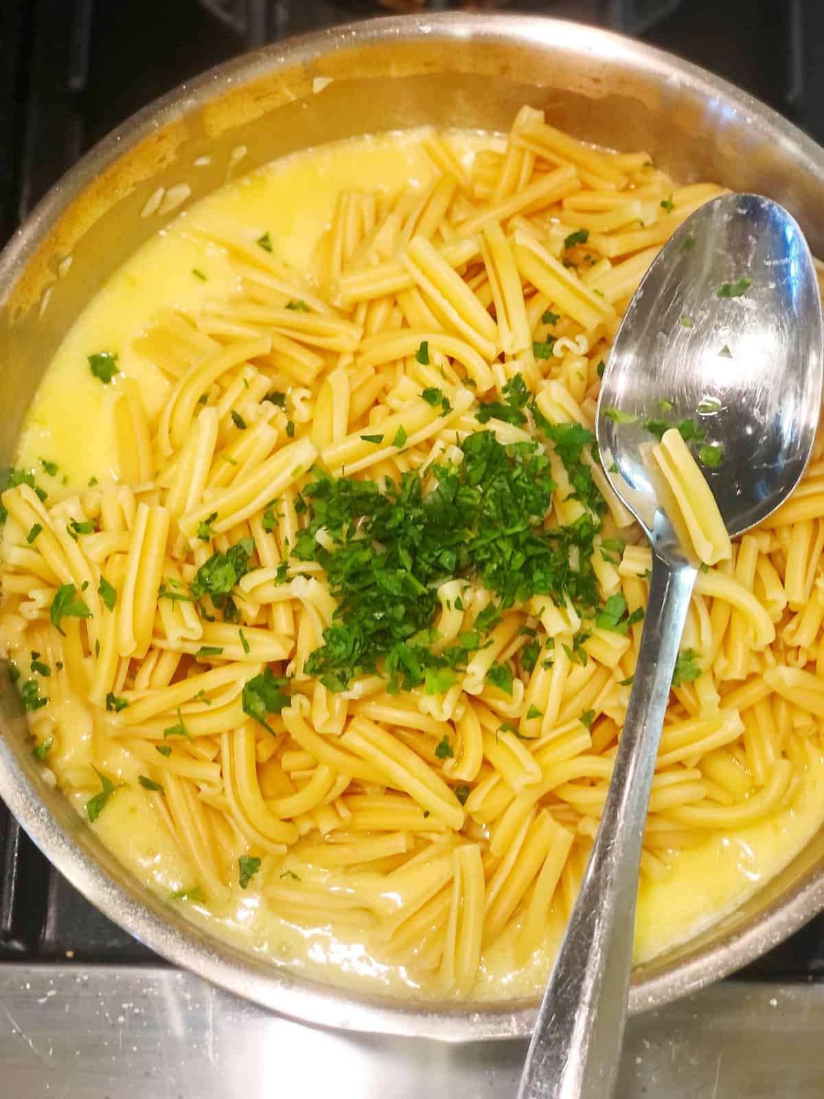 adding pasta to white wine garlic butter sauce