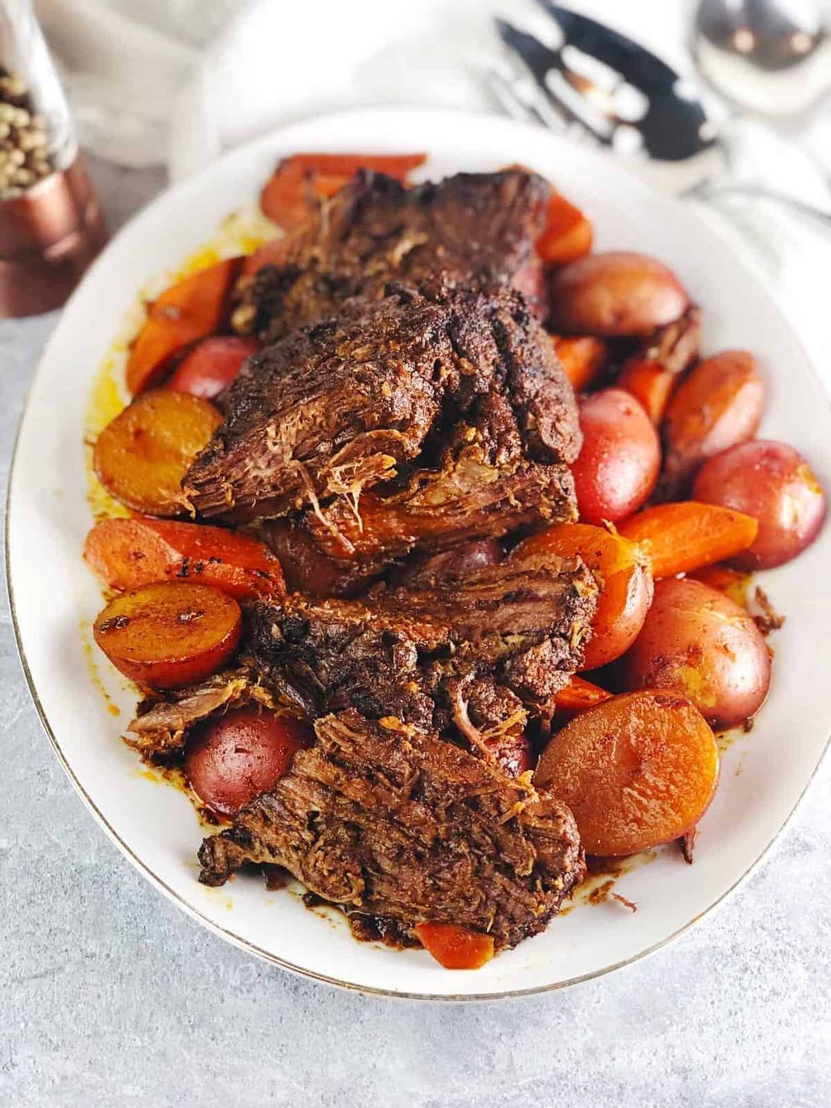 Jewish brisket on plate with carrots and potatoes