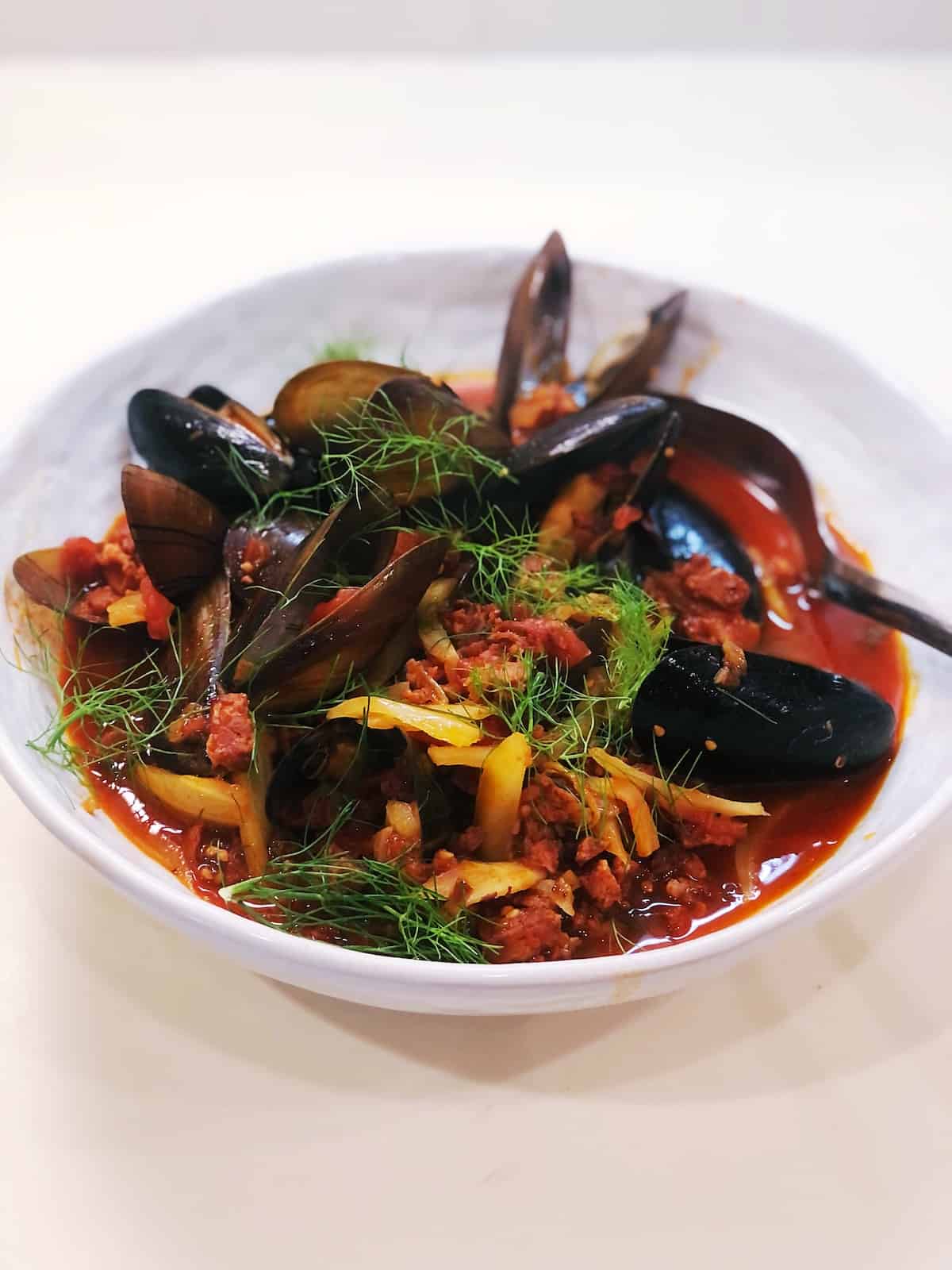 Spanish mussels recipe cooked up in a bowl with bread on top