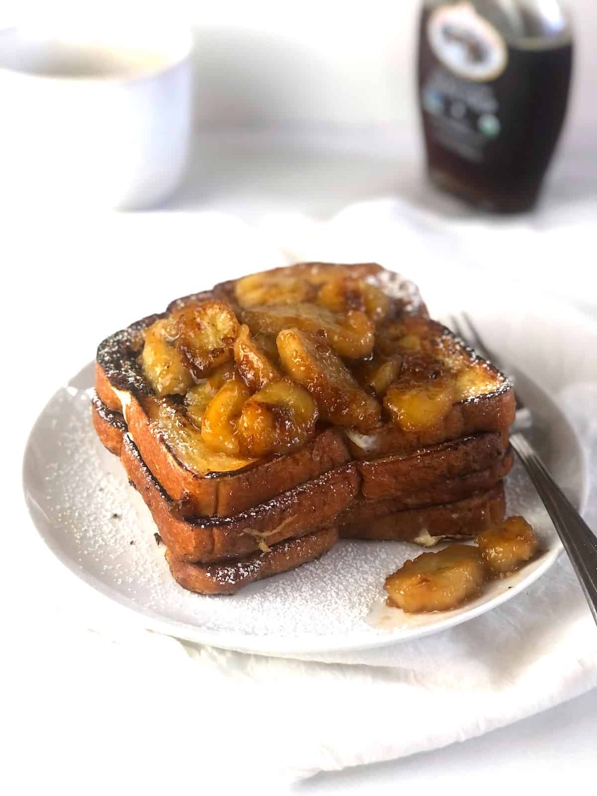 French toast with bananas and syrup on a plate.