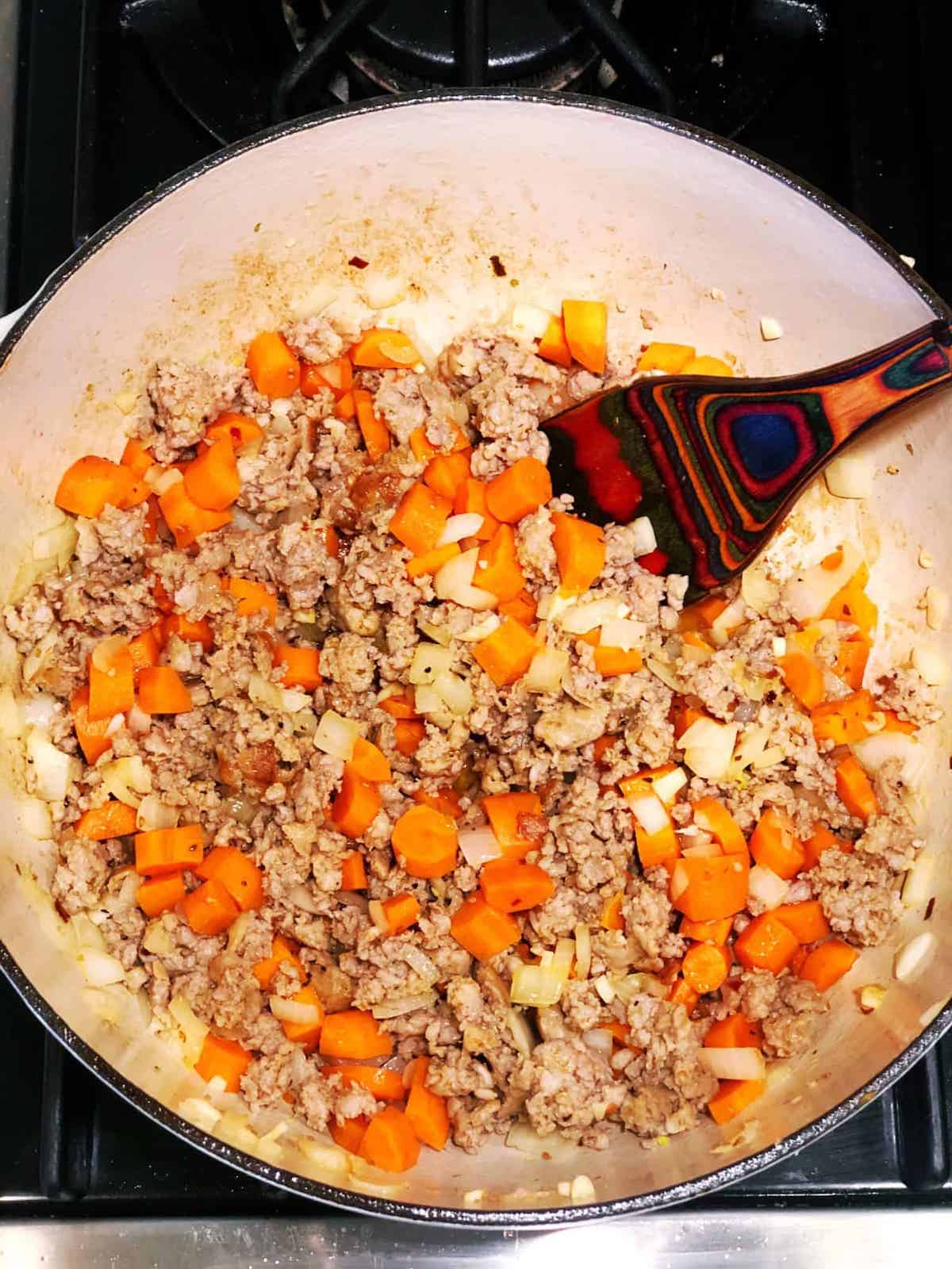 A frying pan filled with meat and vegetables.