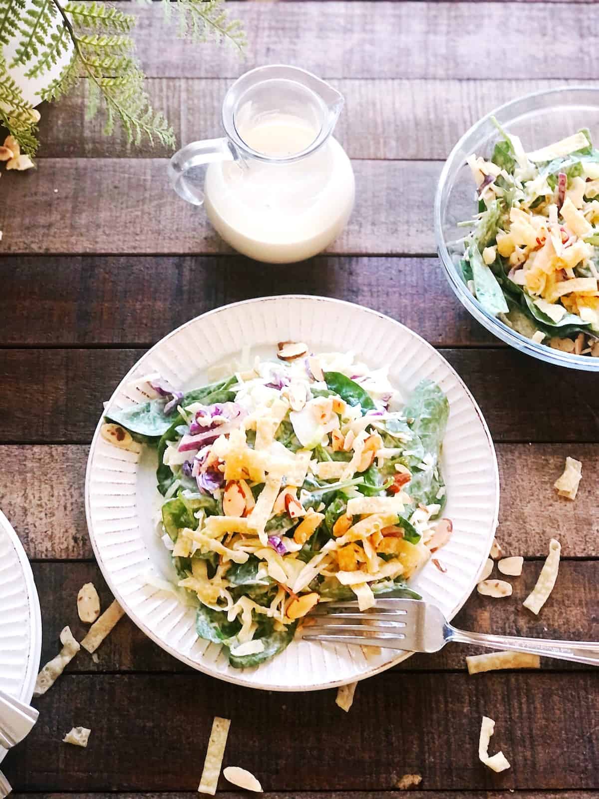 Two plates of salad on a wooden table.
