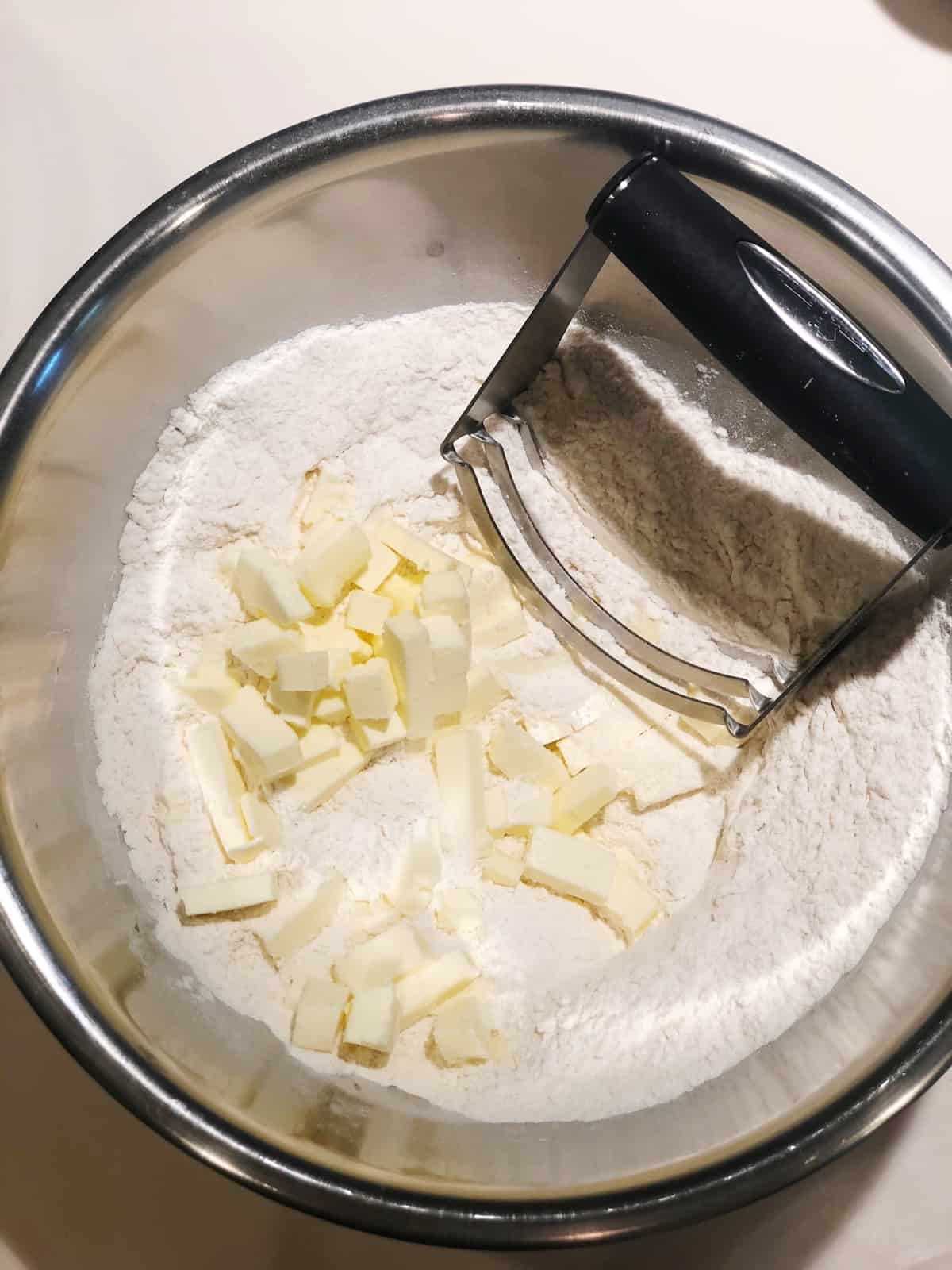 A bowl of flour with a grater in it.