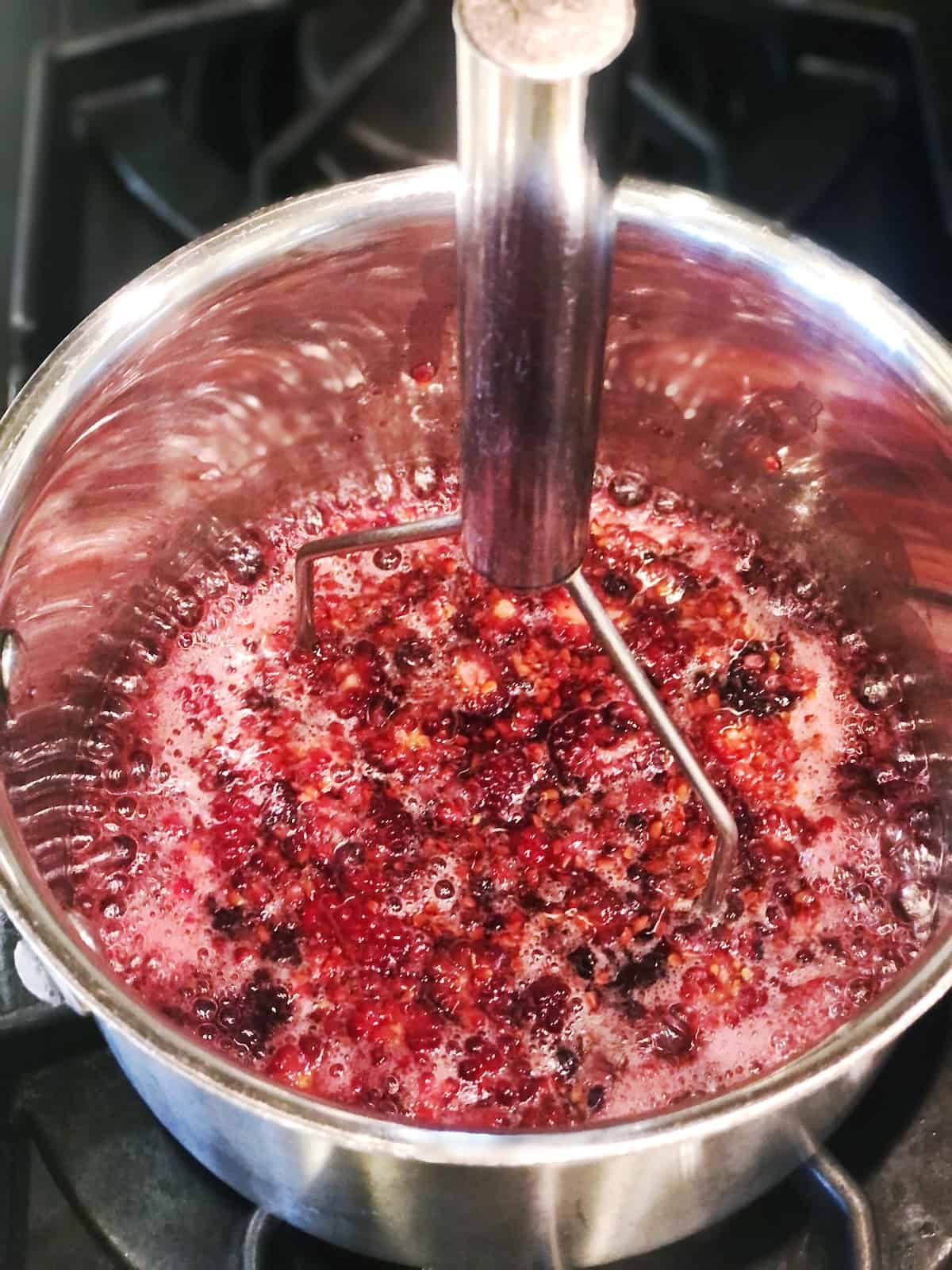 A pan with berries in it on a stove top.