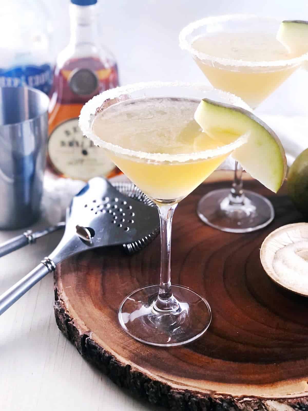 pear martinis on a wood block with martini ingredients in the background