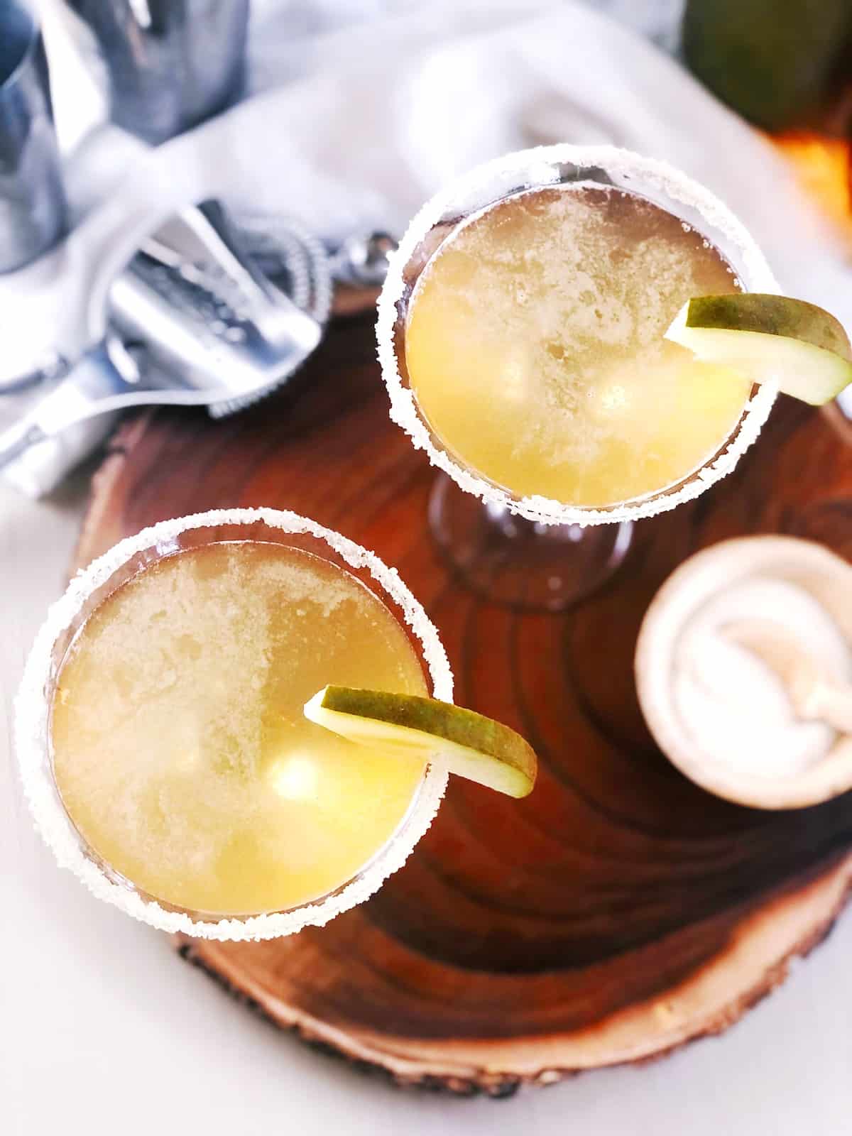 top view of two pear martinis on wood board.