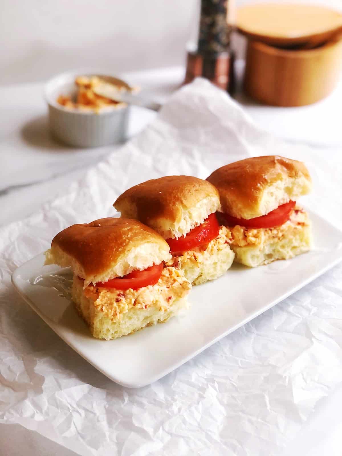 A plate with three sandwiches on it.