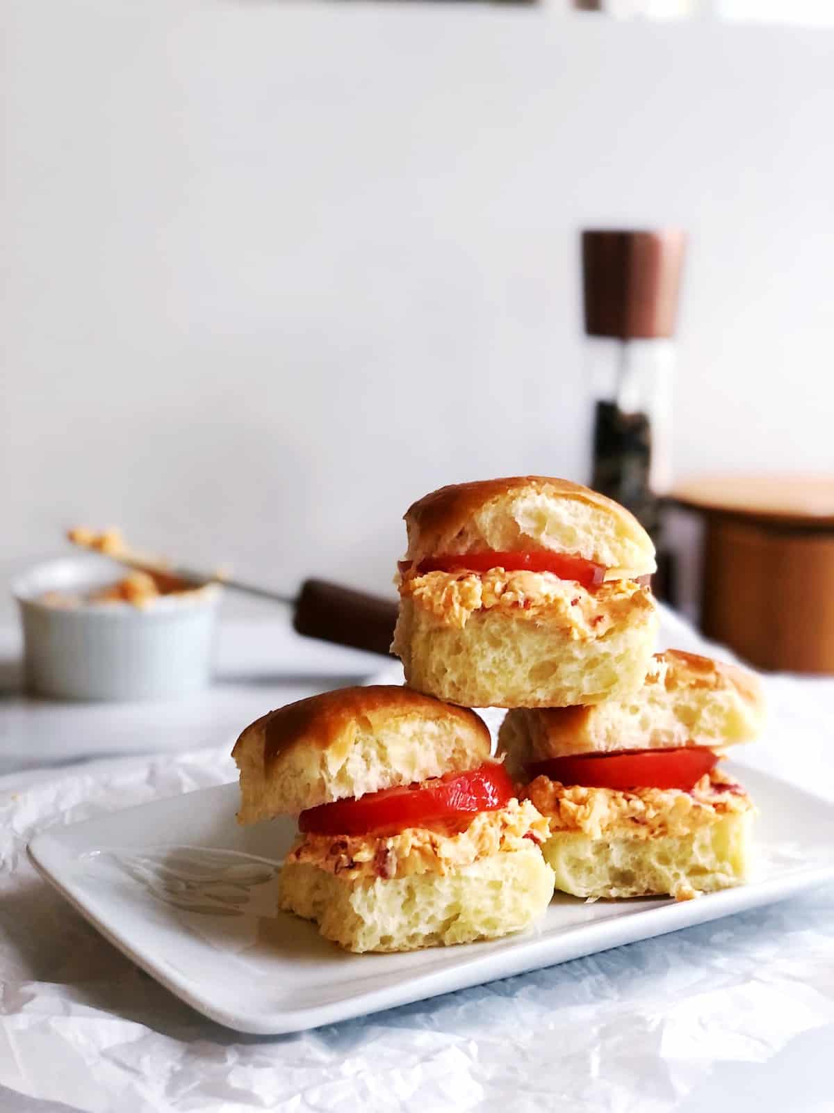 A plate topped with a sandwich with tomatoes and cheese.