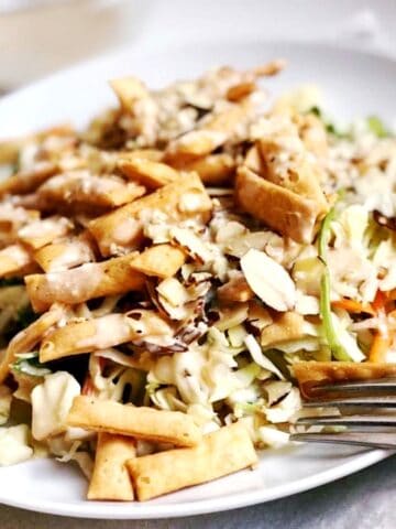 A plate of asian salad with a fork.
