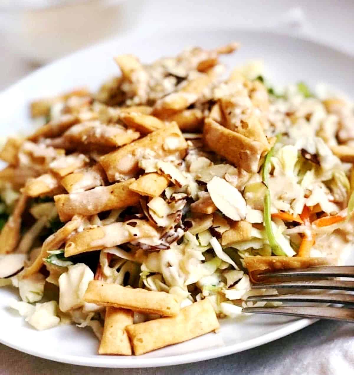 A plate of asian salad with a fork.