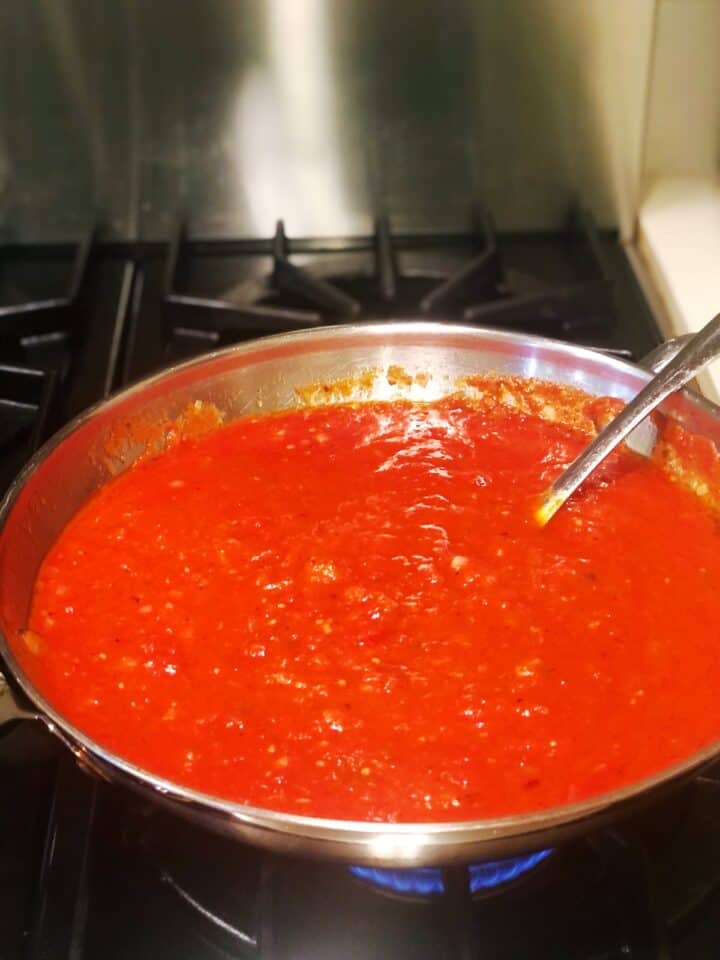 A pan of tomato sauce on a stove top.