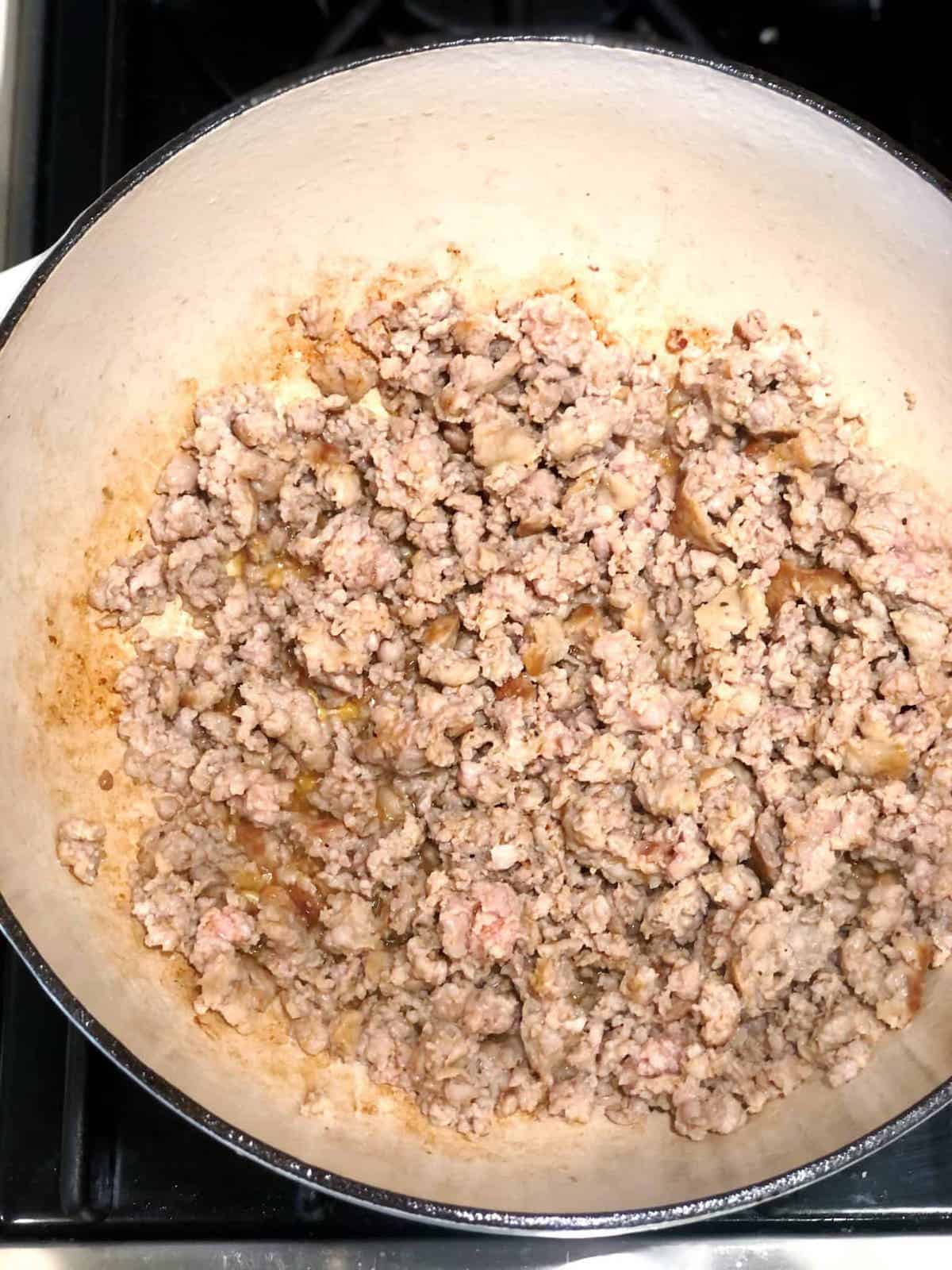 A pan with meat in it on top of a stove.