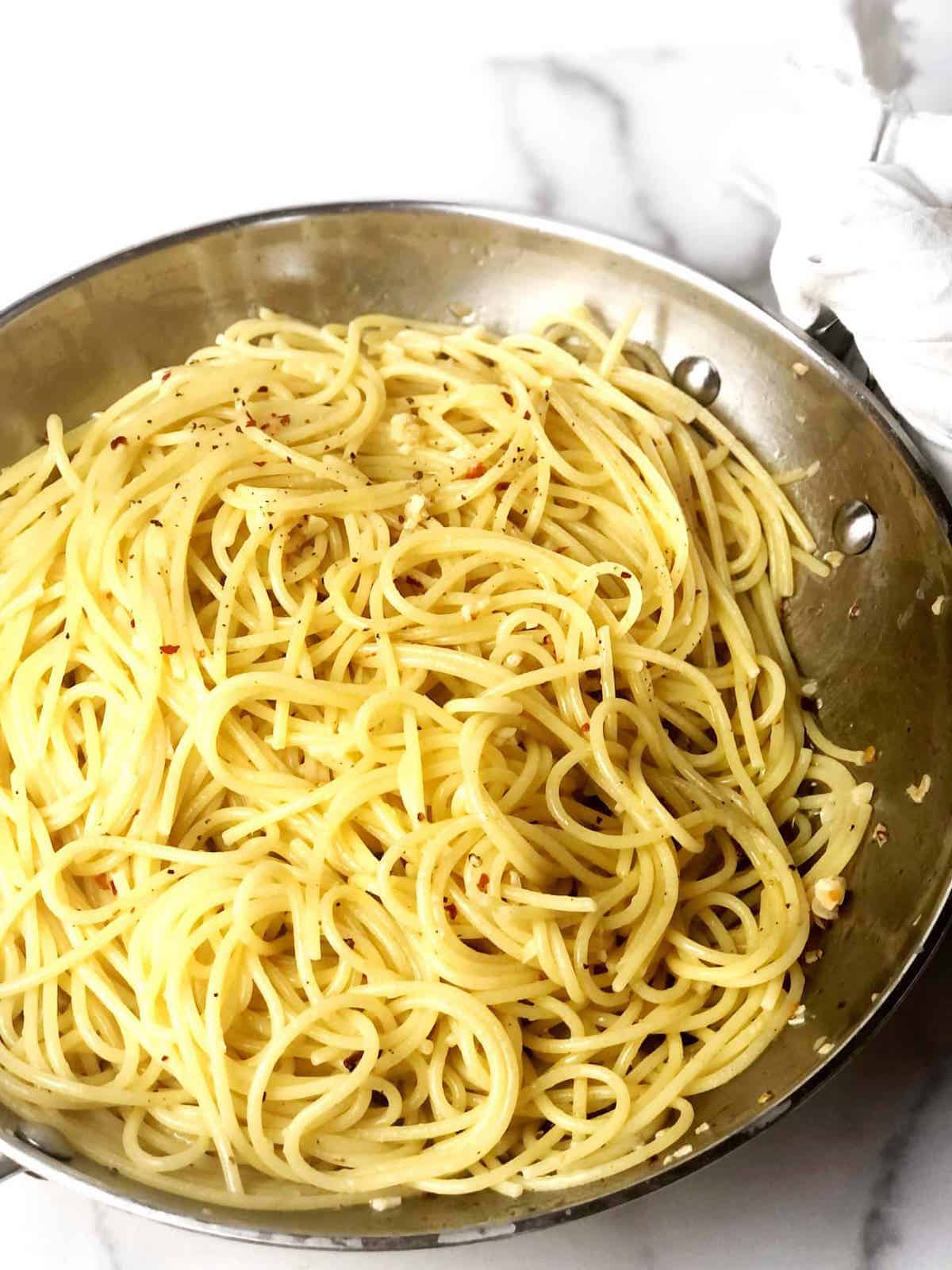 A pan full of spaghetti in a white bowl.