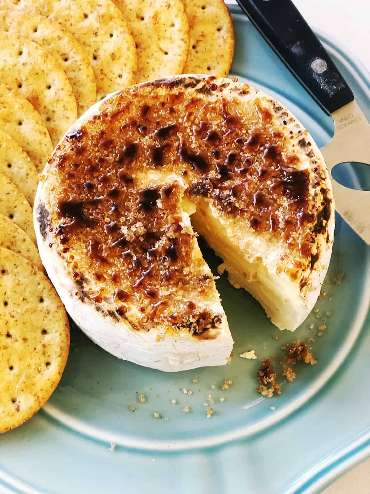 A plate with cheese and crackers on it.