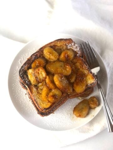 A plate of french toast with bananas on it.
