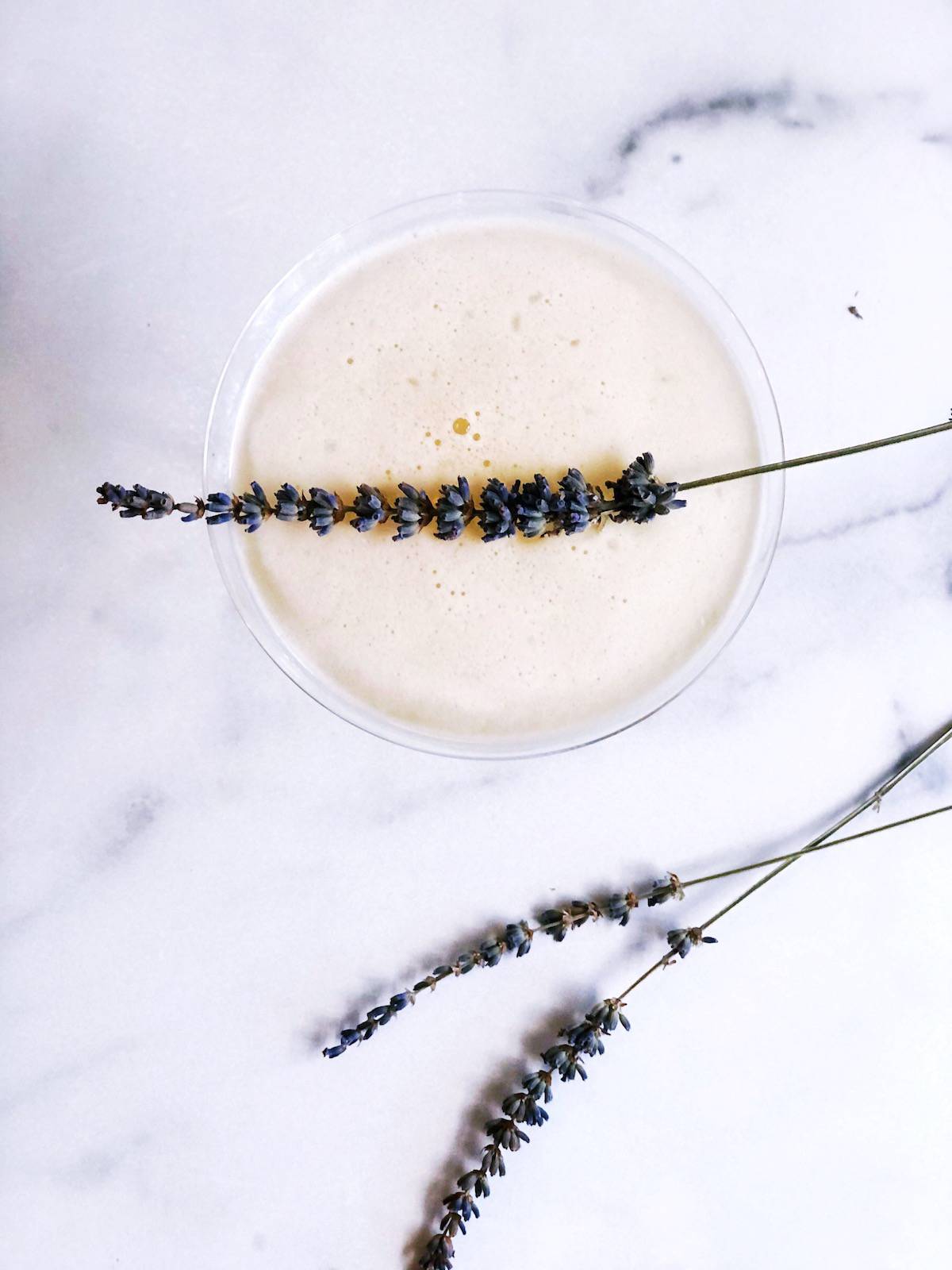 A martini glass with lavender flowers on it.