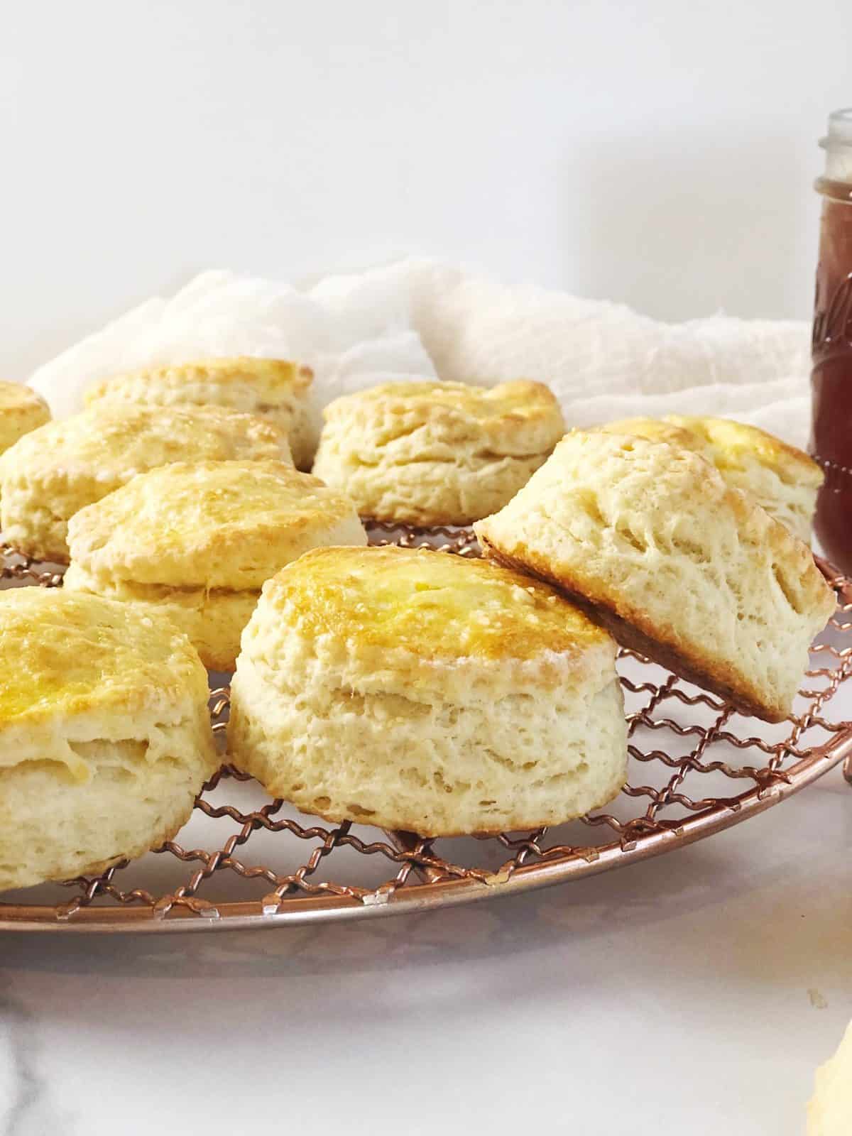 Biscuits on a cooling rack with a jar of jam.