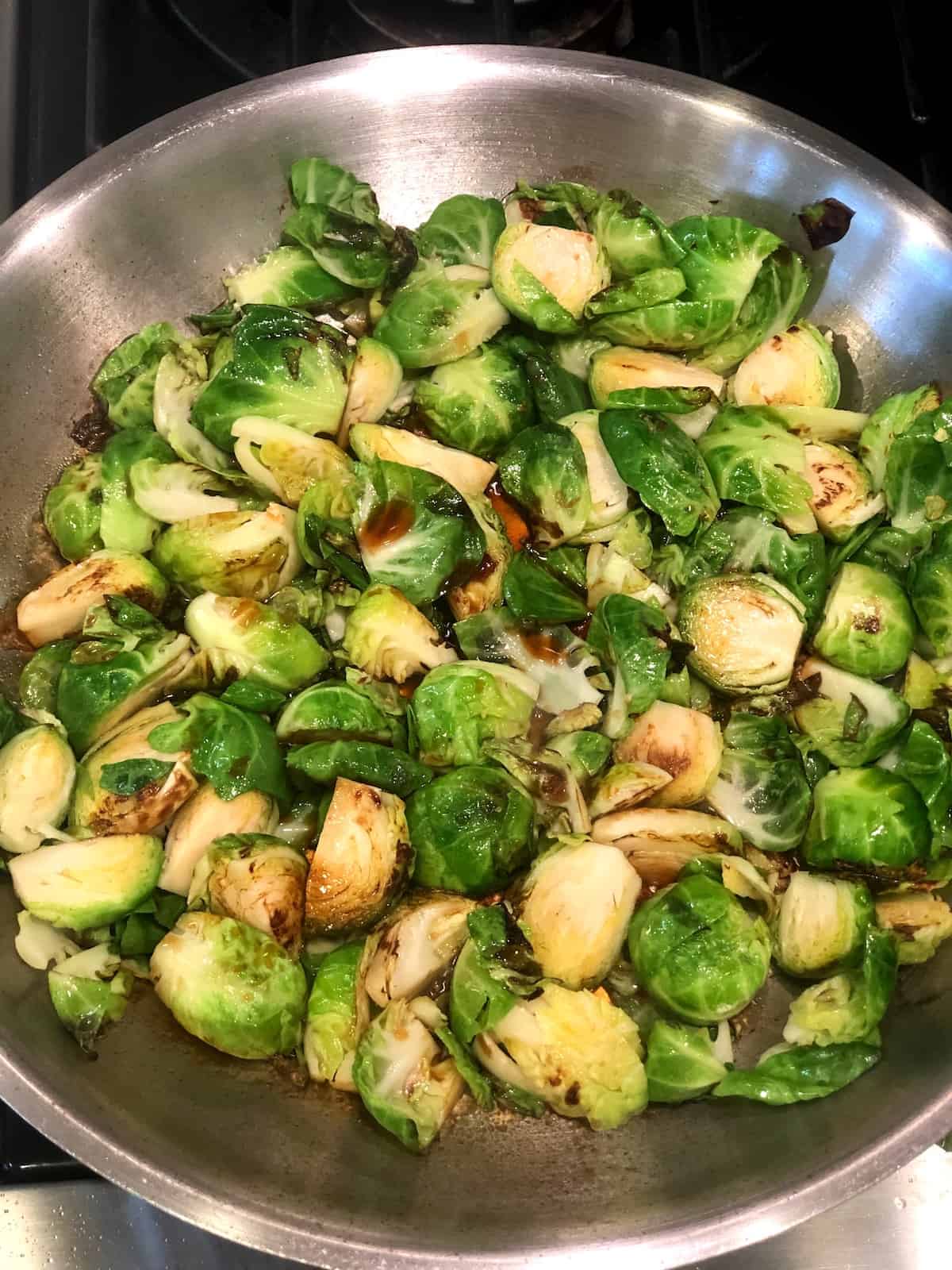 Asian Brussels sprouts in a pan on the stove.