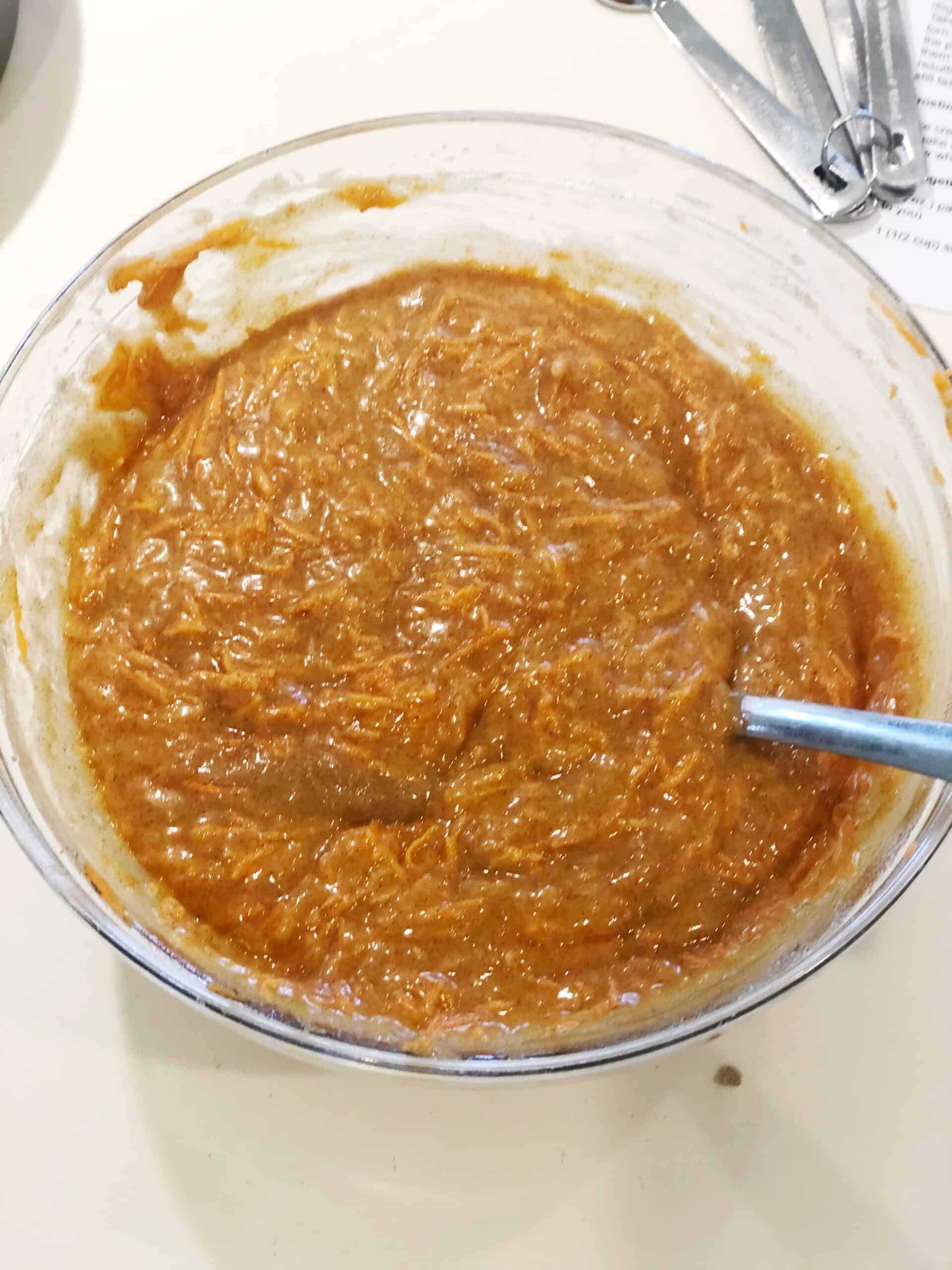 A bowl of batter with a spoon in it.