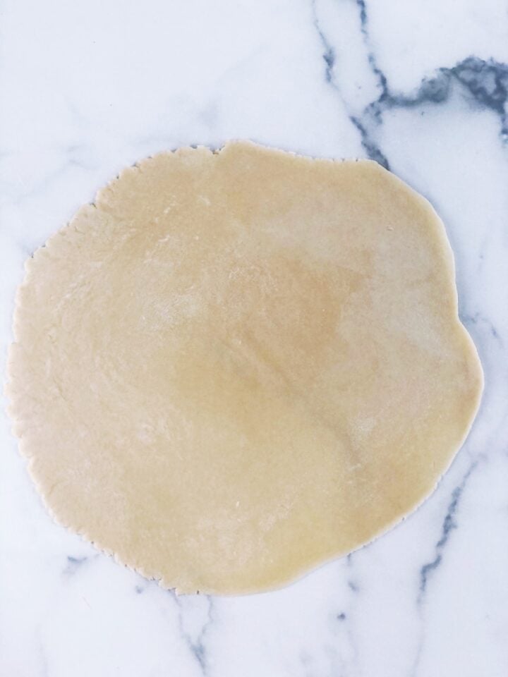 A piece of dough on a marble surface.