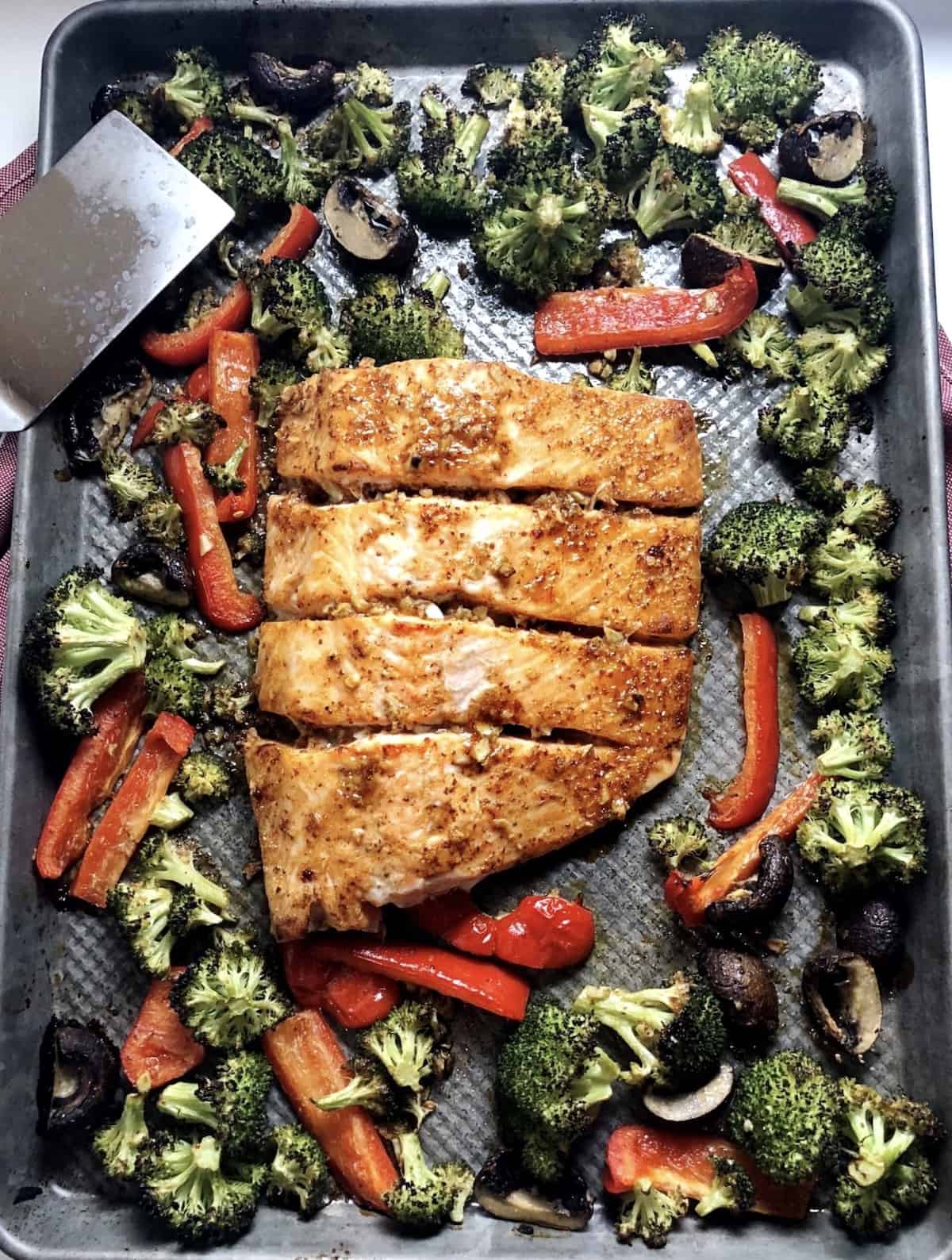 A pan with salmon and broccoli on it.