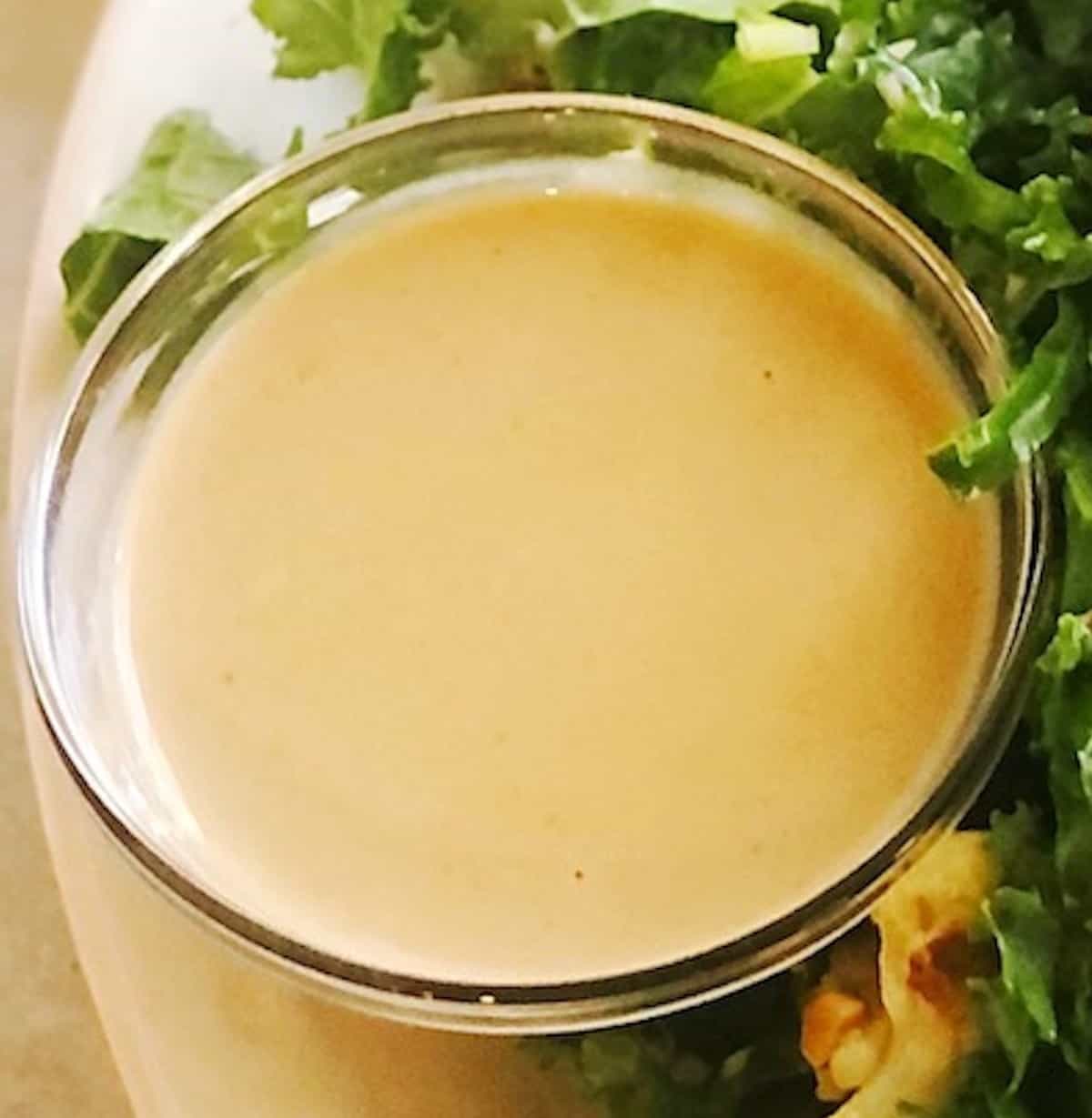 A bowl of tahini dipping sauce on a plate.