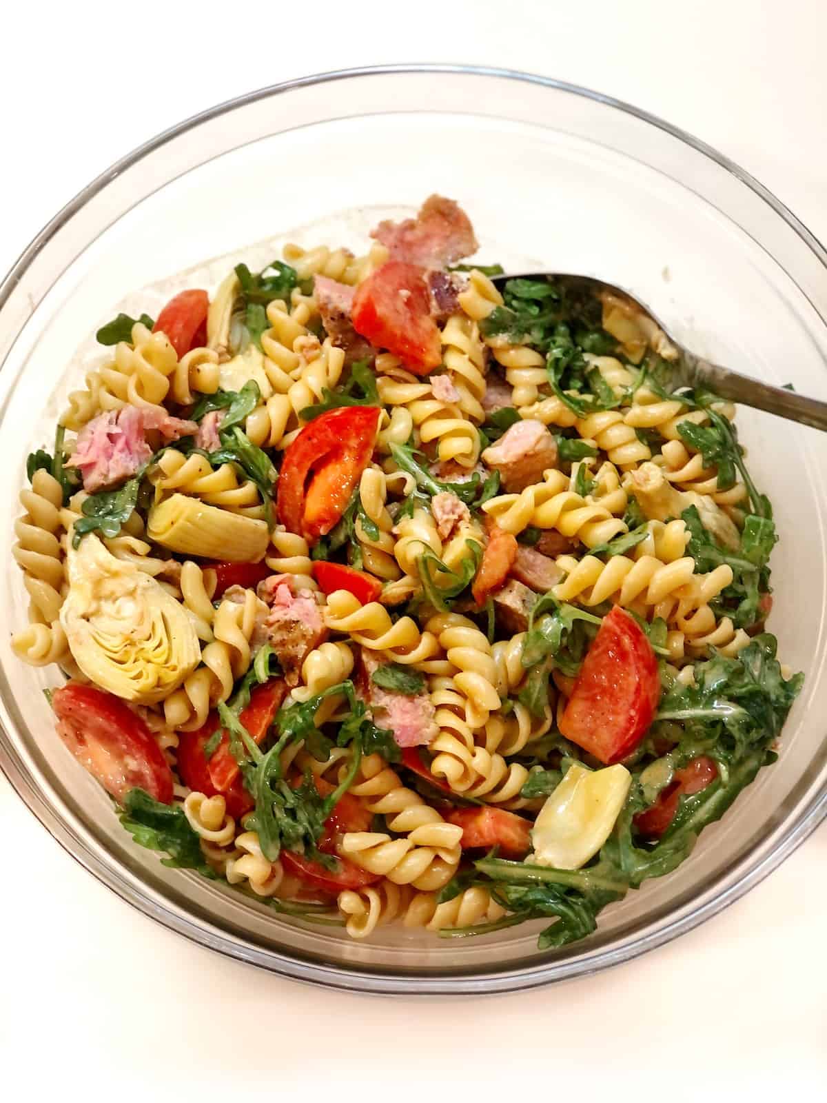 Tuna pasta salad recipe in glass bowl with a spoon