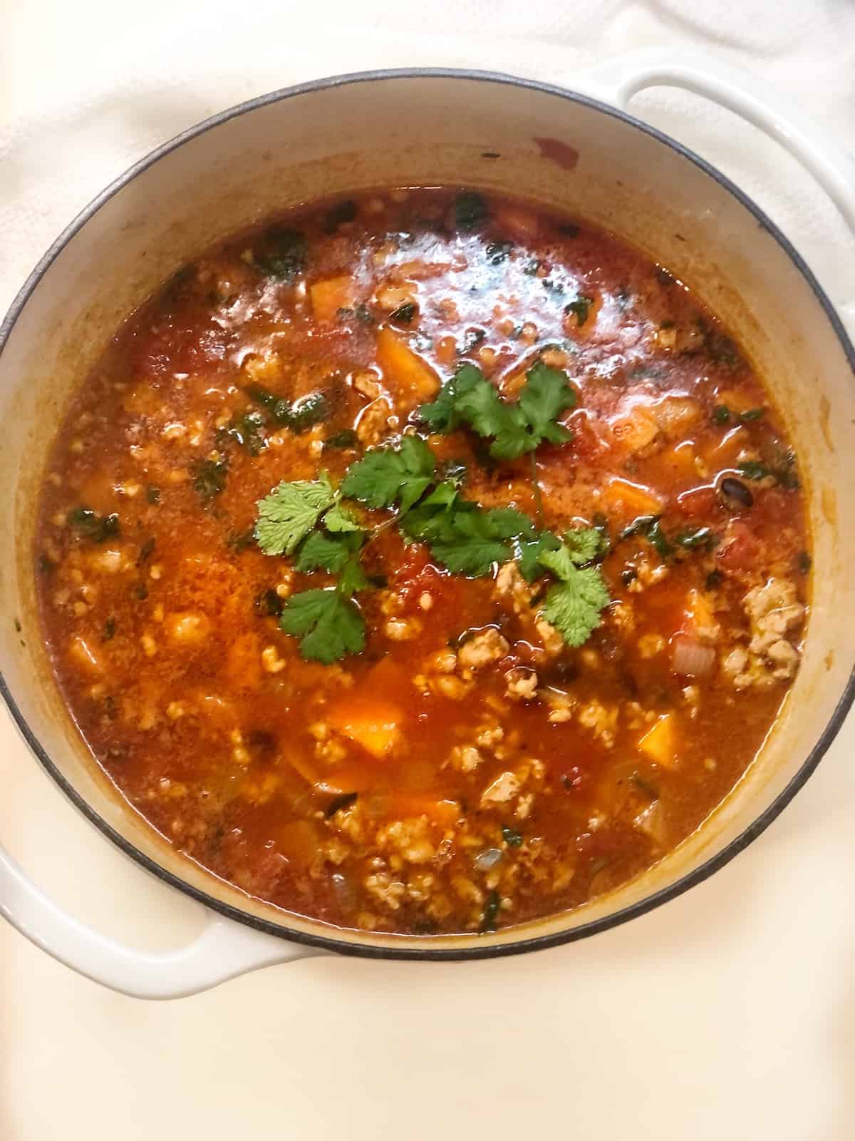 spicy sausage black bean and sweet potato soup in pot