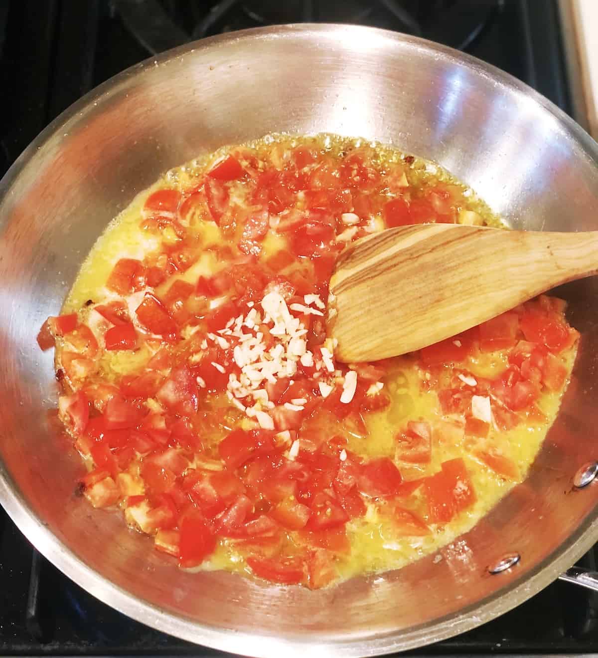 cooking pasta with anchovy butter in a large skillet on the stovetop.