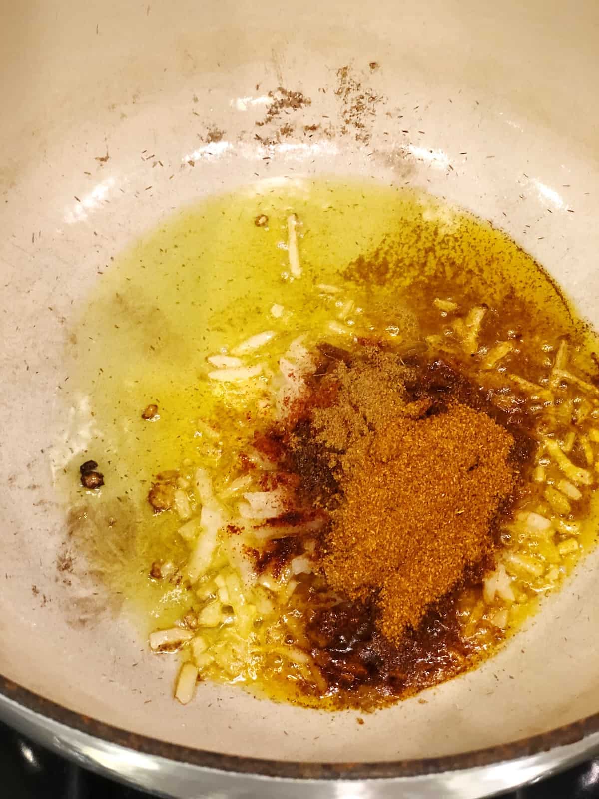 Cooking onions, garlic and spices in a large pot.