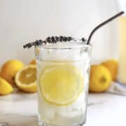 lavender and honey lemonade in a glass with a straw.