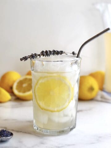 lavender and honey lemonade in a glass with a straw.