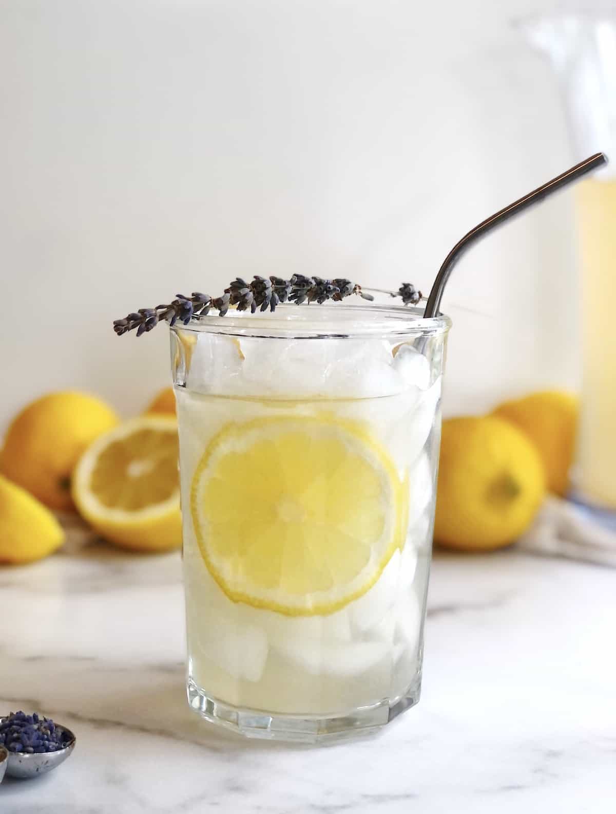 lavender and honey lemonade in a glass with a straw.