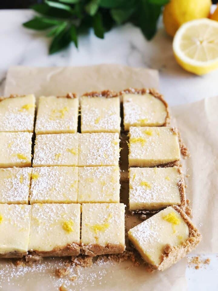 Close view of the creamy lemon bars on parchment paper.