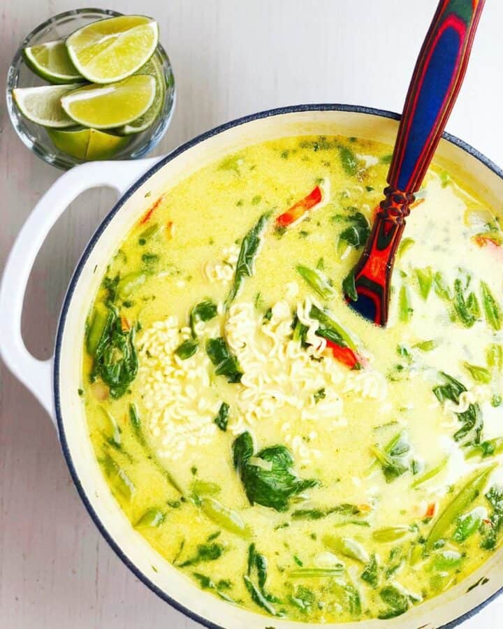 coconut curry soup in a large pot with a spoon.