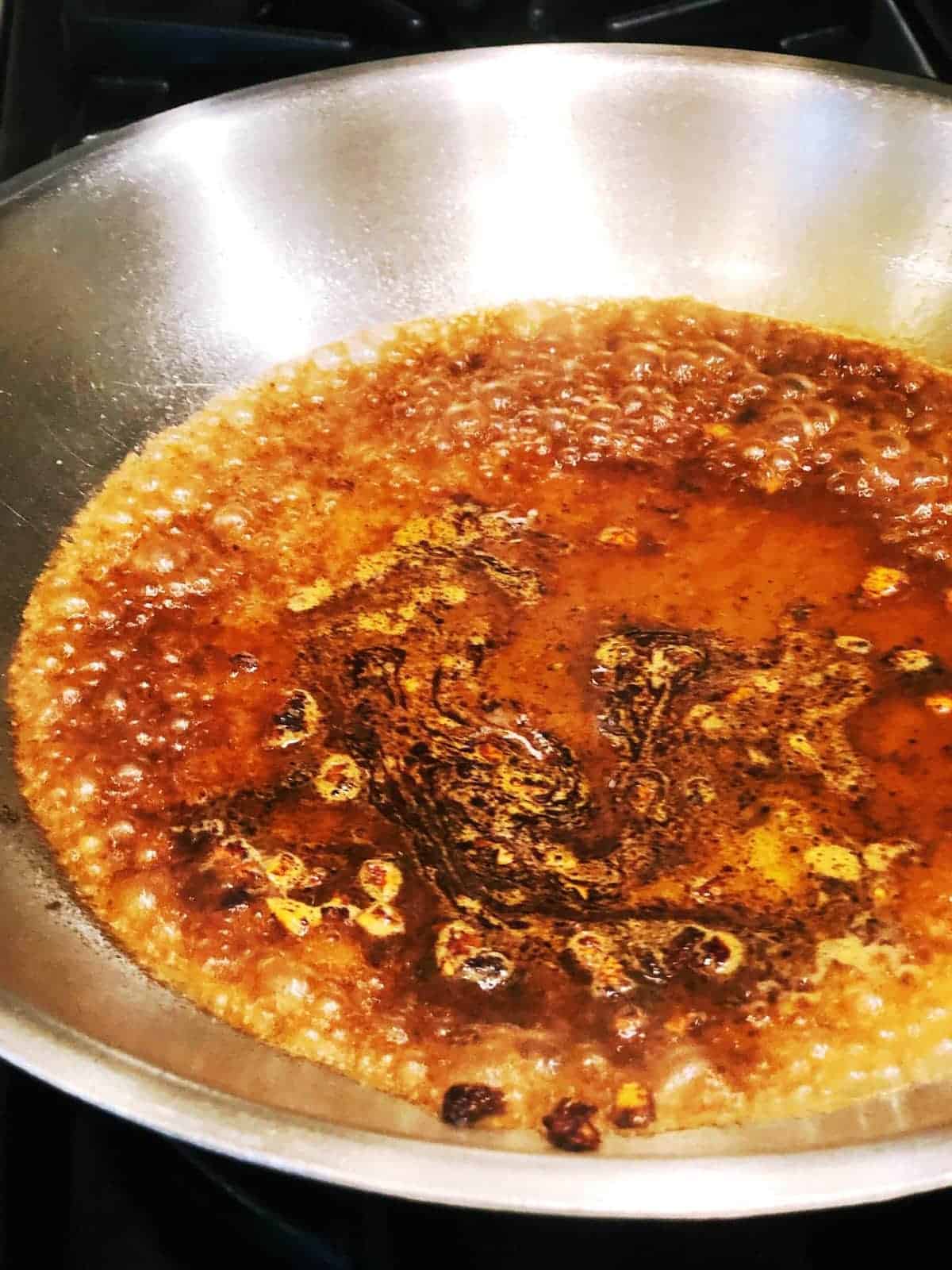 Pot roast searing in pan with juices.
