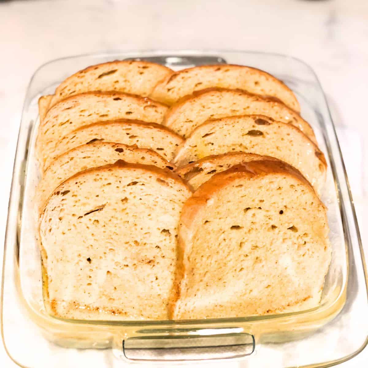Bread with custard poured over the top in a casserole dish.